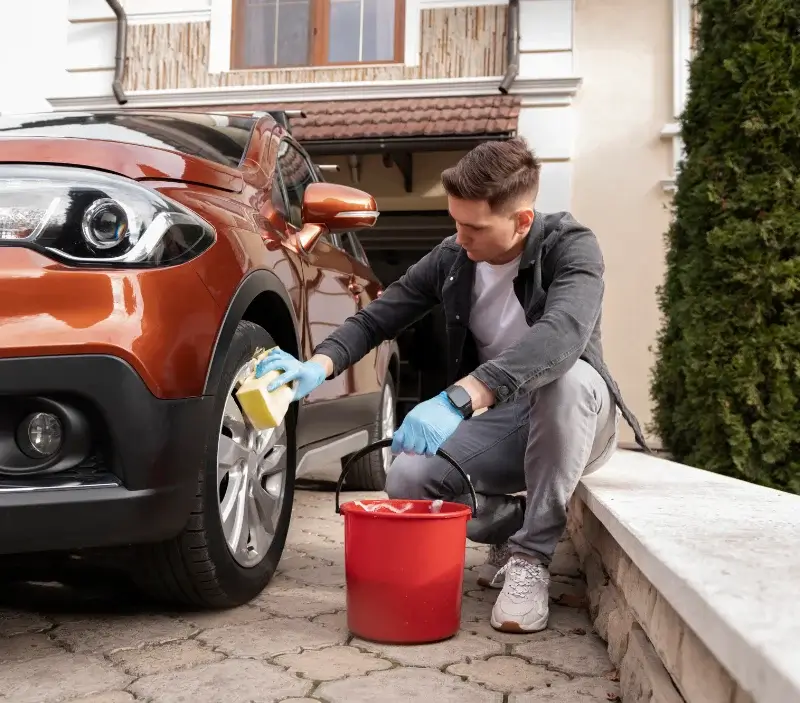 Lavage auto à domicile Souligné-sous-Ballon : professionnel intervenant sur un véhicule